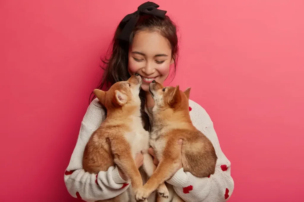 Une jeune femme heureuse câline deux chiens adoptés